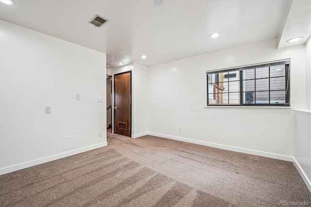 spare room with recessed lighting, carpet, visible vents, and baseboards