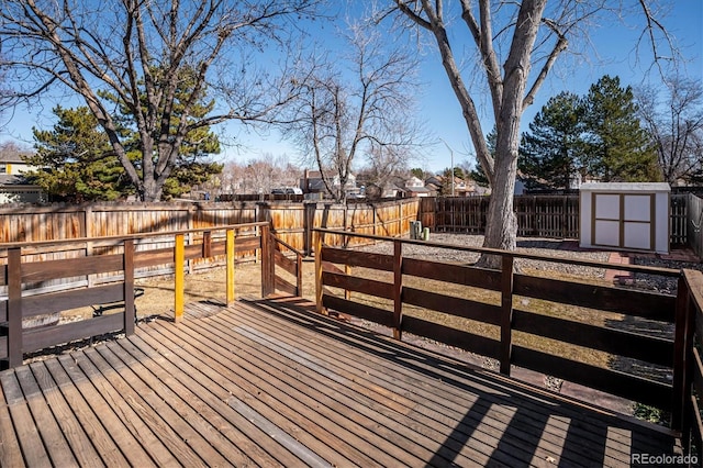 wooden deck with an outbuilding, a shed, and a fenced backyard