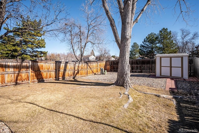 view of yard featuring a storage shed, an outdoor structure, and a fenced backyard