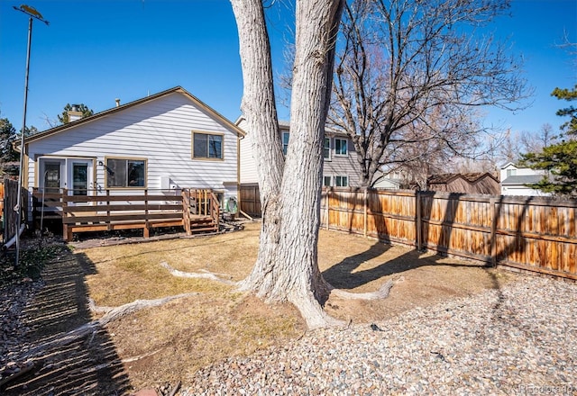 rear view of property with a deck and fence private yard