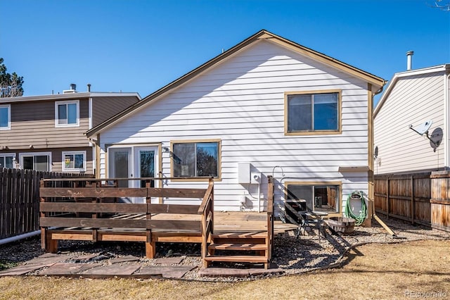 rear view of property featuring a fenced backyard and a wooden deck