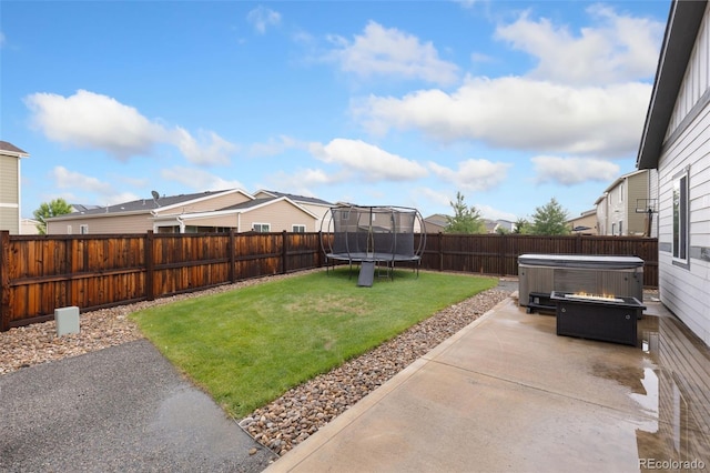 1108 Huntington Ave, Dacono, CO 80514 - fenced backyard featuring a patio, a trampoline, a hot tub, and a residential view