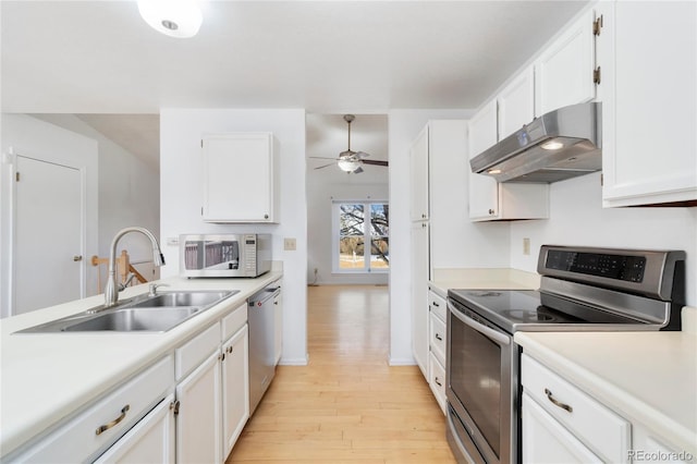 kitchen with appliances with stainless steel finishes, sink, white cabinets, ceiling fan, and light wood-type flooring