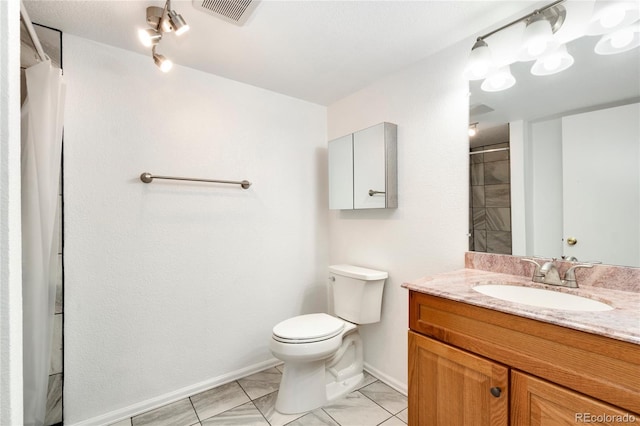 bathroom featuring vanity, walk in shower, and toilet