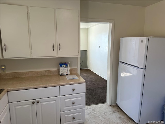 11549 Frederick St, Fort Lupton, CO 80621 - kitchen with freestanding refrigerator, white cabinets, light countertops, and light marble finish floors