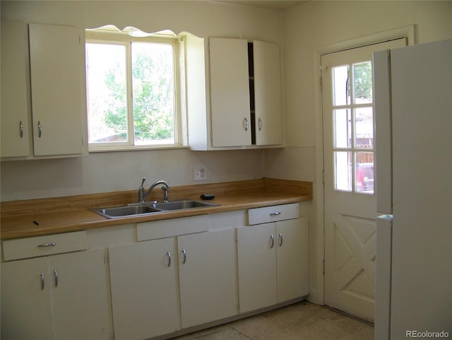 11549 Frederick St, Fort Lupton, CO 80621 - kitchen with freestanding refrigerator, a sink, healthy amount of natural light, and white cabinetry