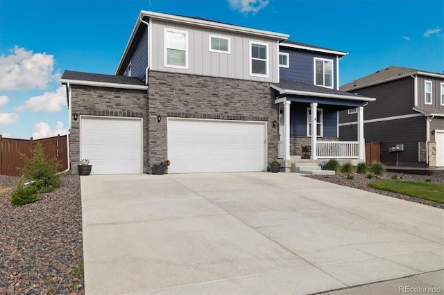 353 Raven Ln, Johnstown, CO 80534 - view of front of home with stone siding, a porch, driveway, and a garage