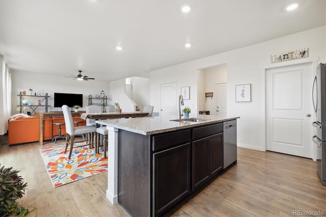 353 Raven Ln, Johnstown, CO 80534 - kitchen with stainless steel appliances, a sink, light wood-style flooring, a ceiling fan, and light stone countertops