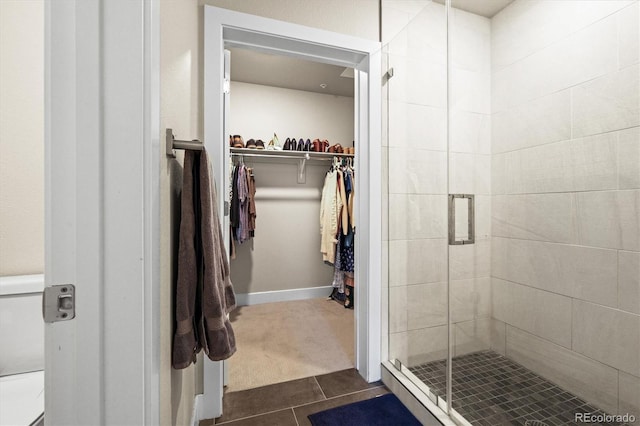 bathroom with tile patterned floors and a shower with door