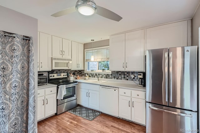 kitchen with ceiling fan, white cabinets, stainless steel appliances, and light hardwood / wood-style flooring