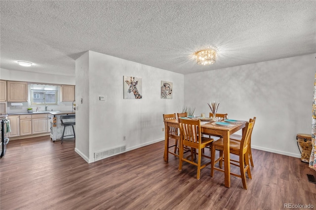 dining area featuring a textured ceiling, dark wood finished floors, visible vents, and baseboards