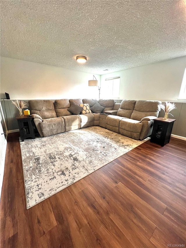 living area with dark wood-style floors and a textured ceiling