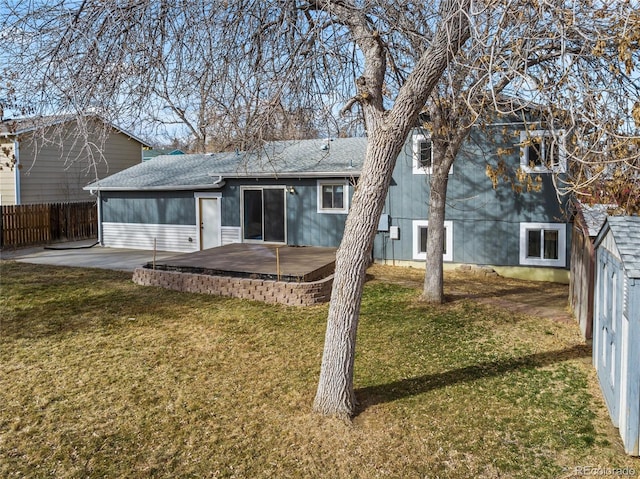 rear view of house featuring a patio, a yard, and a fenced backyard