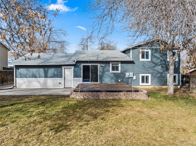 back of property featuring a yard, roof with shingles, a patio, and fence