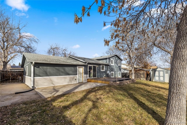 view of front of home featuring fence, a storage unit, an outdoor structure, a patio area, and a front yard