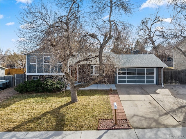 view of front facade featuring brick siding, concrete driveway, an attached garage, a front yard, and fence