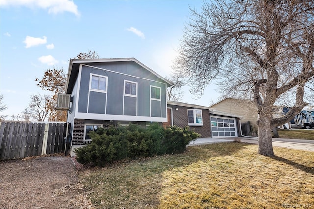 view of front of property featuring an attached garage, brick siding, fence, driveway, and a front lawn