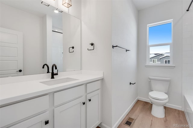 full bathroom with shower / washtub combination, vanity, wood-type flooring, and toilet