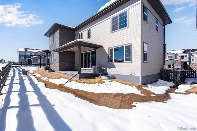 snow covered rear of property with cooling unit