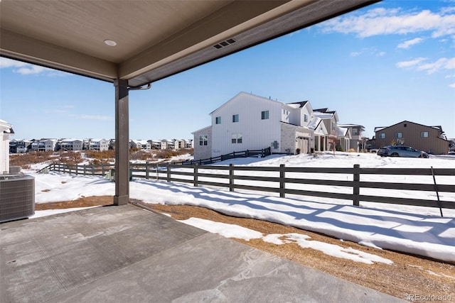 snow covered patio featuring cooling unit