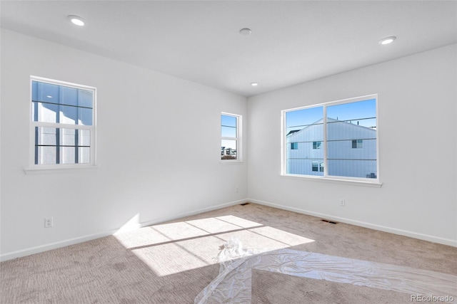 unfurnished room featuring light colored carpet