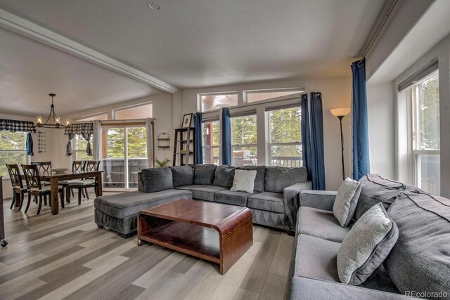 492 Kimmes Ln, Breckenridge, CO 80424 - living room featuring a chandelier, light wood finished floors, healthy amount of natural light, and beamed ceiling