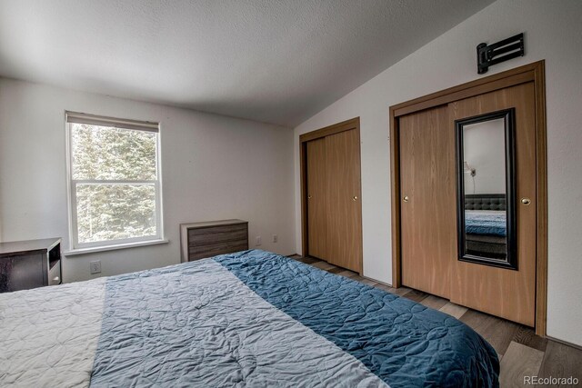 492 Kimmes Ln, Breckenridge, CO 80424 - bedroom featuring vaulted ceiling, multiple closets, wood finished floors, and a textured ceiling