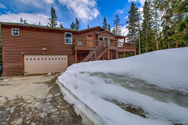 492 Kimmes Ln, Breckenridge, CO 80424 - view of front facade featuring an attached garage, faux log siding, driveway, a wooden deck, and stairway