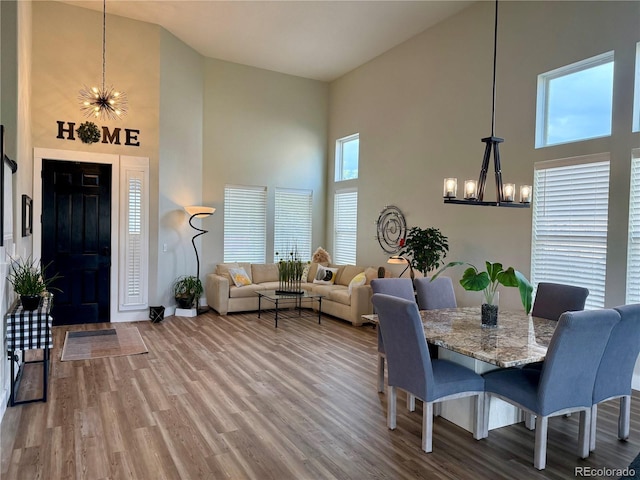 653 Glenarbor Cir, Longmont, CO 80504 - dining space featuring high vaulted ceiling, a chandelier, wood finished floors, and baseboards