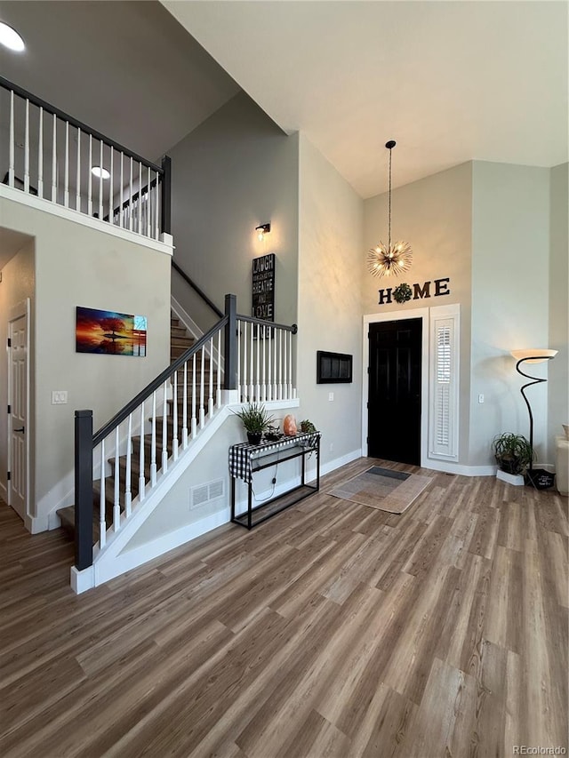 653 Glenarbor Cir, Longmont, CO 80504 - foyer entrance featuring a towering ceiling, wood finished floors, baseboards, stairway, and a chandelier