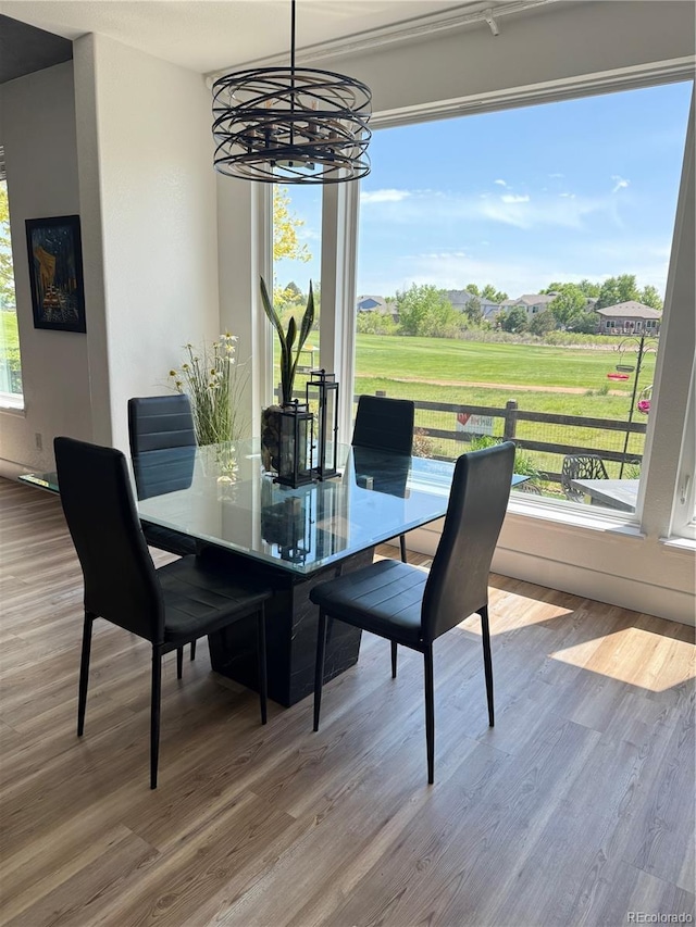 653 Glenarbor Cir, Longmont, CO 80504 - dining room featuring a chandelier, wood finished floors, and golf course view