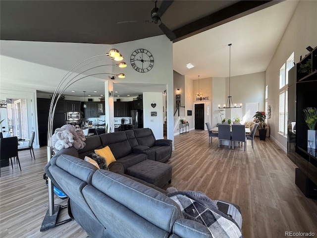 653 Glenarbor Cir, Longmont, CO 80504 - living room featuring a chandelier, high vaulted ceiling, light wood-style flooring, ceiling fan, and beamed ceiling