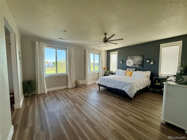 653 Glenarbor Cir, Longmont, CO 80504 - bedroom featuring a textured ceiling, wood finished floors, baseboards, and ceiling fan