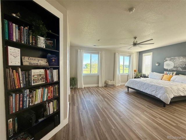 653 Glenarbor Cir, Longmont, CO 80504 - bedroom featuring a textured ceiling, wood finished floors, baseboards, and a ceiling fan