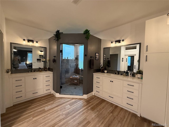653 Glenarbor Cir, Longmont, CO 80504 - bathroom featuring wood finished floors, ensuite bath, a shower stall, vanity, and lofted ceiling
