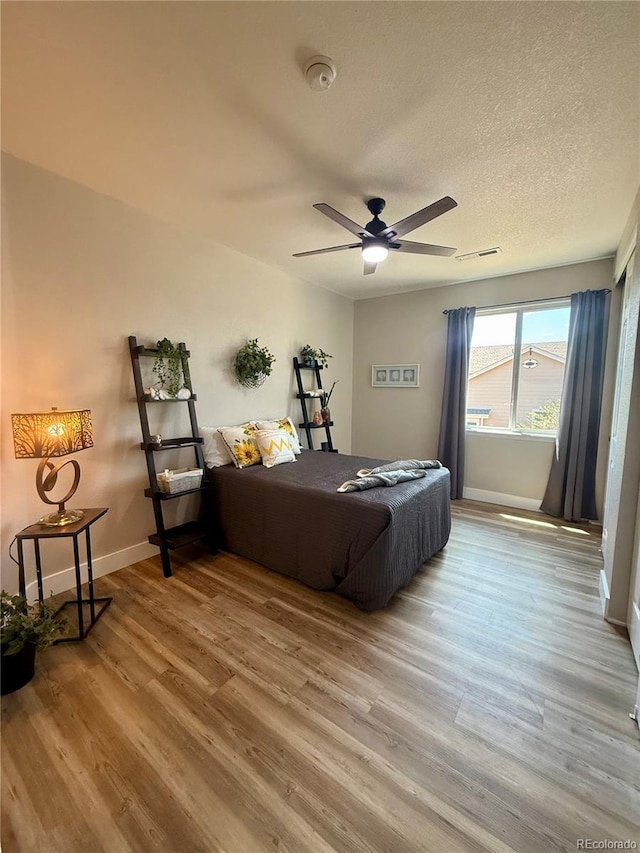 653 Glenarbor Cir, Longmont, CO 80504 - bedroom with wood finished floors, baseboards, a textured ceiling, and ceiling fan