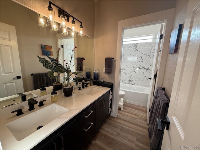 653 Glenarbor Cir, Longmont, CO 80504 - full bathroom with toilet, double vanity, wood finished floors, and shower / bathtub combination
