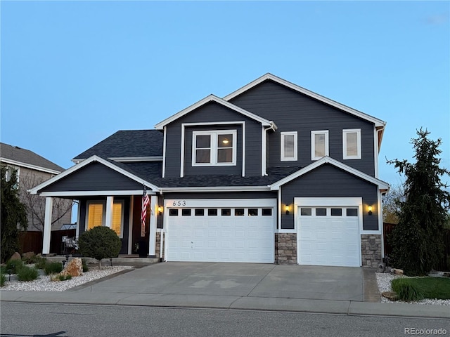 653 Glenarbor Cir, Longmont, CO 80504 - view of front of property with a garage, concrete driveway, covered porch, stone siding, and a shingled roof