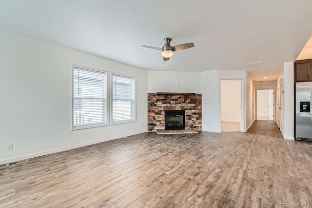 6261 Red Cedar St, Frederick, CO 80530 - unfurnished living room featuring visible vents, a fireplace, light wood-style flooring, a ceiling fan, and baseboards