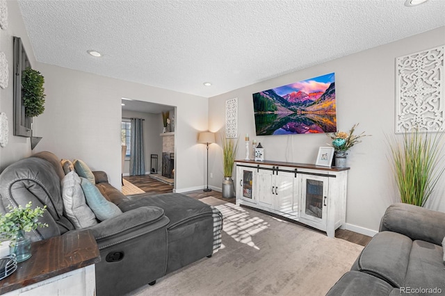 4733 S Vivian Ct, Morrison, CO 80465 - living area with wood finished floors, a textured ceiling, baseboards, a fireplace, and recessed lighting