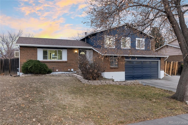 split level home with a yard and a garage