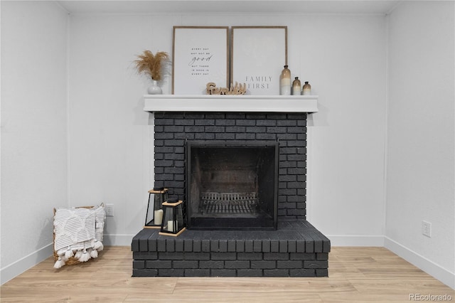 room details with wood-type flooring and a brick fireplace