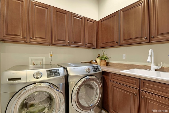 washroom with cabinets, separate washer and dryer, and sink