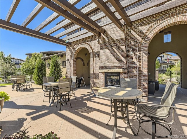 view of patio with an outdoor brick fireplace and a pergola