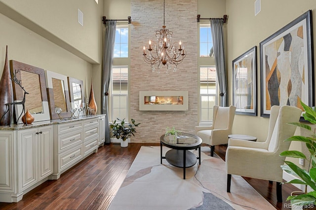 living area featuring dark hardwood / wood-style flooring, plenty of natural light, and a high ceiling