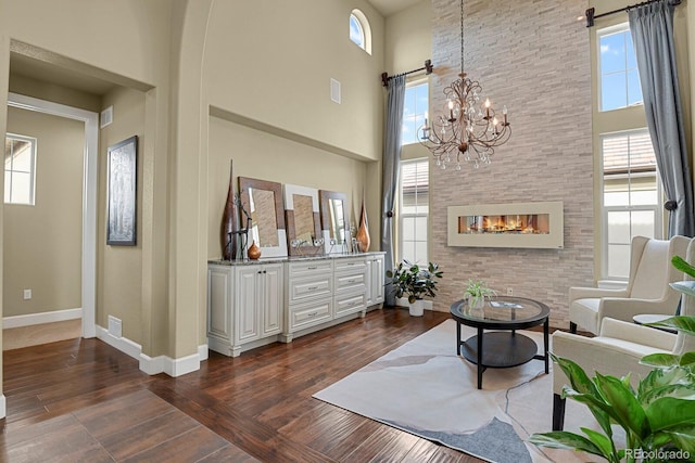 living room with dark hardwood / wood-style floors, a towering ceiling, and a barn door