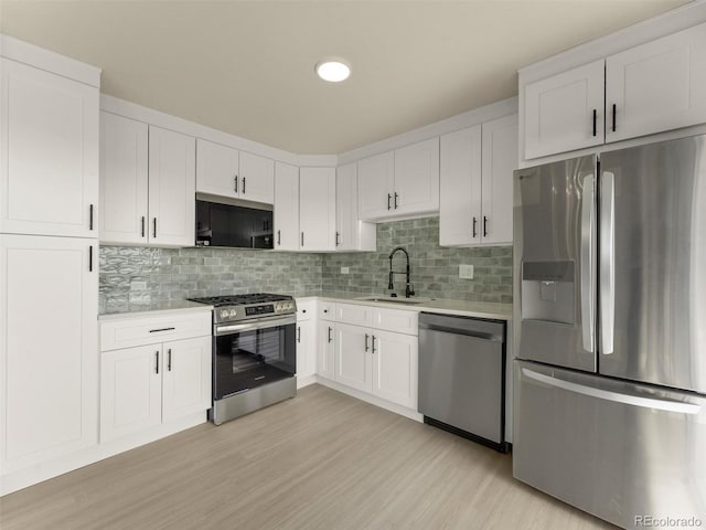 kitchen featuring light countertops, white cabinetry, appliances with stainless steel finishes, and a sink