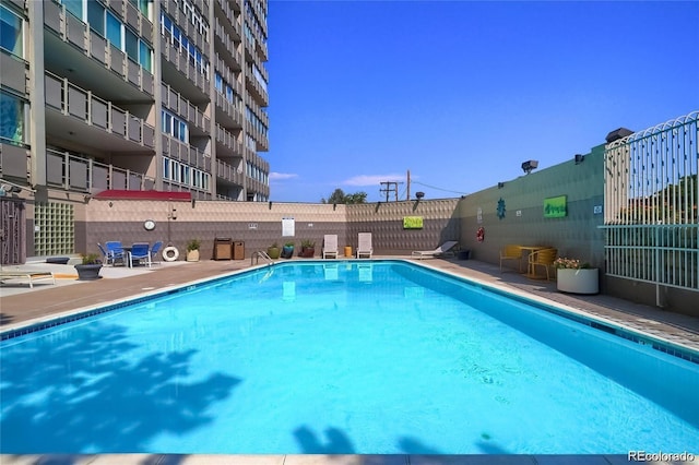 pool with fence and a patio area