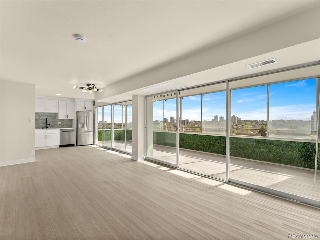 800 N Washington St Unit 1010, Denver, CO 80203 - unfurnished living room with a chandelier and light wood-type flooring