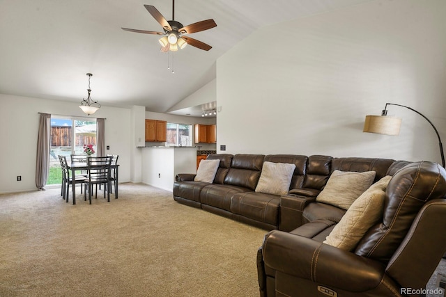 carpeted living room with ceiling fan and high vaulted ceiling